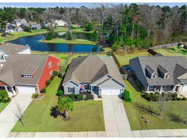 Charming single-story home with well-manicured lawn, mature trees, and a tranquil pond view at 240 Gazania Way, Charleston, SC 29414