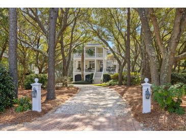 Charming two-story home with a long drive, lush trees, and a welcoming entrance at 2863 Jasper Blvd, Sullivans Island, SC 29482