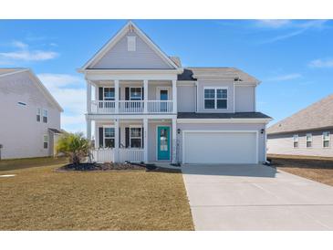 Charming two-story home with a double porch, bright blue door and well-manicured lawn in a Gathering-friendly neighborhood at 415 Ribiero Dr, Summerville, SC 29486
