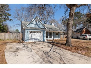 Charming light blue home featuring an attached garage and spacious driveway at 4788 Porter Dr, North Charleston, SC 29420