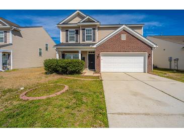 Two-story home featuring a brick facade, attached two-car garage, and well-maintained lawn on a sunny day at 104 Mayfield Dr, Goose Creek, SC 29445