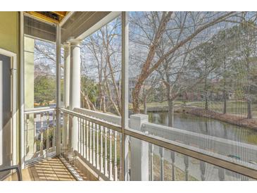 Relaxing screened balcony view of the neighborhood pond and landscape at 1321 Telfair Way, Charleston, SC 29412