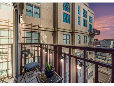 Cozy balcony featuring string lights, outdoor seating, and city views during a colorful sunset at 150 Bee St # 714, Charleston, SC 29401