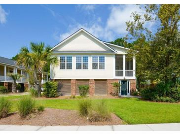 Inviting two-story home featuring well-manicured lawn, tall palm trees, and a lovely screened-in porch at 1717 Rivertowne Country Club Dr, Mount Pleasant, SC 29466
