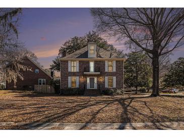 Charming two-story brick home with a balcony and mature trees on a neatly kept lawn at 24 N Basilica Ave, Hanahan, SC 29410