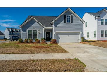 Charming gray two-story home featuring an attached garage and professionally landscaped front yard at 317 Catawba Branch Way, Moncks Corner, SC 29461