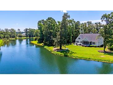 Beautiful home featuring a lake and lush landscaping, creating a serene and picturesque setting at 4162 Ten Shillings Way, Hollywood, SC 29470