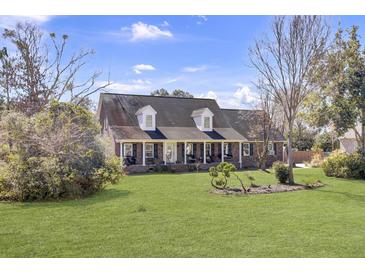 Charming brick home with a large front yard, dormer windows, and inviting front porch at 522 W Butternut Rd, Summerville, SC 29483
