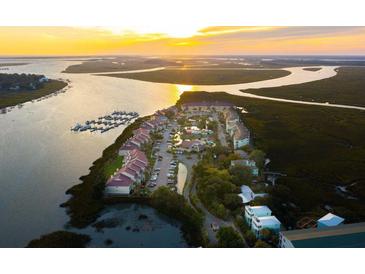 Gorgeous sunset aerial view of harbor side condominiums, docks, and waterway at 166 W Mariners Cay Dr, Folly Beach, SC 29439
