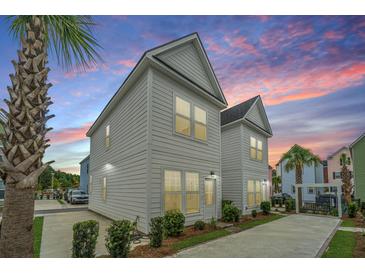 Charming two-story home with sunset backdrop and driveway, surrounded by lush landscaping at 2001 E Patterson Pt, Hanahan, SC 29410