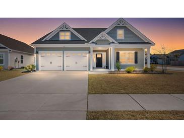 Charming home showcasing a two-car garage, landscaped yard, and craftsman-style architecture at sunset at 224 Fiddleback Dr, Summerville, SC 29486