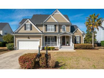 Charming two-story home with a well-manicured lawn, inviting porch, and attached two-car garage at 2972 Riverwood Dr, Mount Pleasant, SC 29466