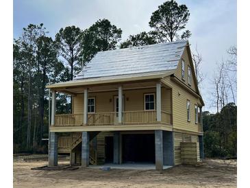 Charming raised home featuring a welcoming porch, elevated design, and classic architectural details at 3102 Hailey Ct, McClellanville, SC 29458