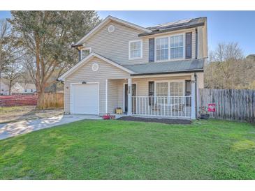 Charming two-story home with a well-maintained lawn, inviting front porch, and attached one-car garage at 2755 Lacy St, North Charleston, SC 29406