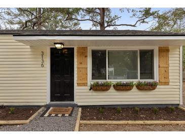 Charming front door with a small porch and rustic shutters adding curb appeal to the exterior of the home at 3136 Terry Dr, North Charleston, SC 29405