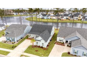 An attractive single-Gathering home is showcased with a well-manicured lawn and a serene water view in the background at 357 Tupelo Lake Dr, Summerville, SC 29486