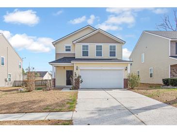 Charming two-story home with yellow siding, a well-manicured lawn, and a two-car garage at 505 Greywood Ln, Goose Creek, SC 29445