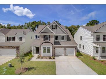Beautiful two-story home boasts a brick facade, two-car garage, and a well-manicured lawn at 525 Verdi Dr, Summerville, SC 29486