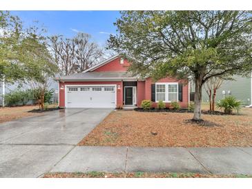 Charming red one-story home featuring a well-manicured lawn and attached two-car garage at 5408 Overland Trl, North Charleston, SC 29420