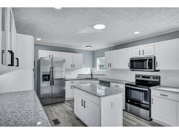 Modern kitchen featuring white cabinets, stainless steel appliances, and gray countertops at 7461 Church Hill Rd, Hollywood, SC 29449