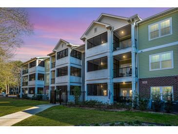 Charming condo building featuring large screened porches and lush landscaping, perfect for enjoying the outdoors at 1025 Riverland Woods Pl # 801, Charleston, SC 29412