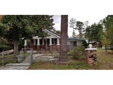 Charming brick home with a small front porch and fenced yard at 107 Grant St, Walterboro, SC 29488