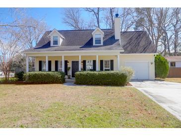 Charming one-story home with covered porch, dormers, manicured bushes, and attached garage at 1656 Lauda Dr, Mount Pleasant, SC 29464