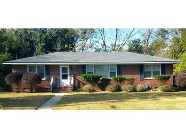 Charming brick home featuring a manicured lawn and mature landscaping at 1902 Morgan Ave, North Charleston, SC 29406
