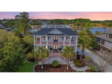 Stunning two-story home with dual staircases, double porches, manicured lawn, palm trees, and spectacular views at 2040 Ashburton Way, Mount Pleasant, SC 29466