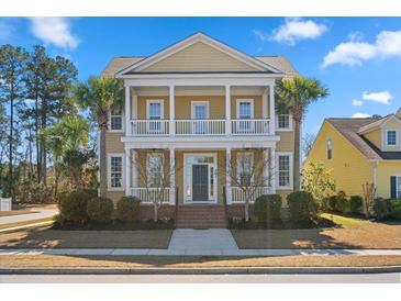 Charming two-story home featuring a double porch, landscaped yard, and palm trees at 301 Forsythia Ave, Summerville, SC 29483