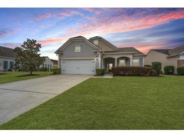 Charming single-Gathering home with a well-manicured lawn, mature tree, and covered front porch at 303 Sand Dune Trl, Summerville, SC 29486
