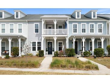 Charming townhouse with double porch, white railings, and beautiful landscaping at 3125 Sturbridge Rd, Mount Pleasant, SC 29466