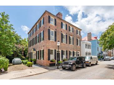 Classic brick home featuring black shutters and a well-manicured lawn on a sunny day at 41 Tradd St, Charleston, SC 29401