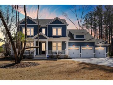 Charming two-story home featuring a welcoming front porch and a spacious three-car garage at 5680 Barbary Coast Rd, Hollywood, SC 29449