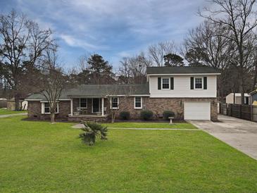 Charming two-story brick home with a well-manicured front lawn, mature trees, and attached one car garage at 760 Royle Rd, Ladson, SC 29456