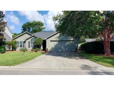Charming one-story home featuring a well-maintained lawn, mature trees, and an attached two car garage at 1310 Pilsdon Crest, Mount Pleasant, SC 29464
