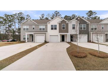 Charming townhomes featuring varied siding colors, attached garages, and concrete driveways lined by well manicured lawns at 205 Cozy Brook Ct, Summerville, SC 29486