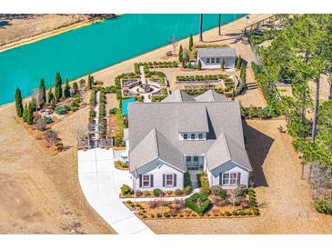 Stunning aerial view of a charming home with lush landscaping and a beautiful pond in a desirable community at 225 Camber Rd, Huger, SC 29450