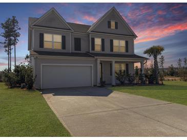 Charming two-story home with a well-manicured lawn, a two-car garage and a beautiful dusk sky at 265 Celestial Blvd, Summerville, SC 29486