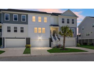 Charming townhome featuring a two-car garage, covered entry and manicured lawn at 305 Lanyard St, Johns Island, SC 29455
