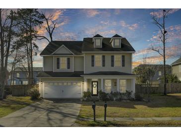 Charming two-story home boasts a welcoming front porch and well-maintained landscaping at sunset at 314 Foxbank Plantation Blvd, Moncks Corner, SC 29461