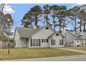 Charming one-story home with grey siding and dark shutters surrounded by mature trees at 4064 Bonaparte Dr, North Charleston, SC 29418