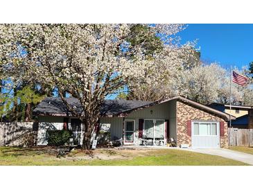 Charming single-story home featuring a brick facade, flowering tree, and well-maintained front yard at 105 Ford Ct, Summerville, SC 29483