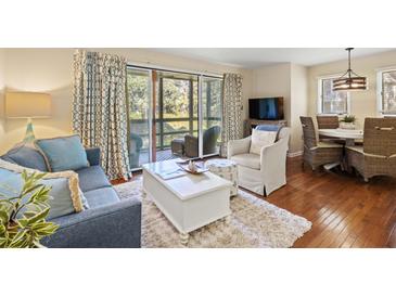 Inviting living room features a comfortable seating area, a sliding glass door to the balcony, and stylish decor at 1407 Shipwatch Rd, Kiawah Island, SC 29455