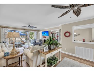 Cozy living room features hardwood floors, ceiling fan, and access to the outdoor patio at 15 Back Ct, Isle of Palms, SC 29451