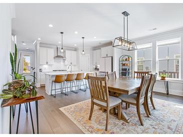 Bright dining area with a wooden table set on an ornate rug, lit by a modern light fixture at 170 Callibluff Dr, Summerville, SC 29486