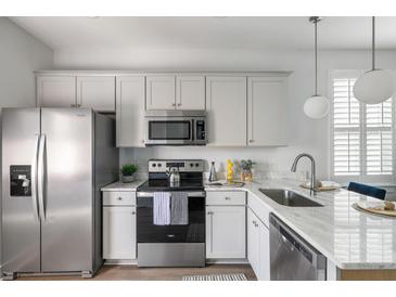 Bright kitchen features stainless steel appliances and white cabinetry at 2021 Arbutus Ave, North Charleston, SC 29405