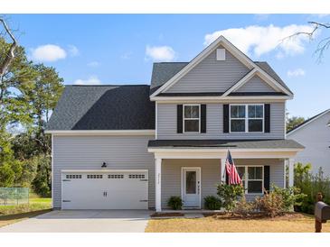 Charming two-story home featuring gray siding, a well-manicured lawn, attached garage, and inviting front porch at 2312 Oakland Rd, Charleston, SC 29414