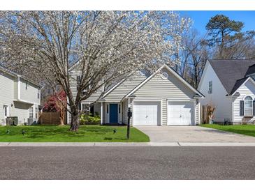 Charming two-story home with a blue door, two-car garage, and a beautiful flowering tree in the front yard at 350 Arlington Dr, Charleston, SC 29414
