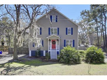 Charming two-story home with blue shutters, a red door, and mature trees providing shade at 3651 Barton St, Johns Island, SC 29455